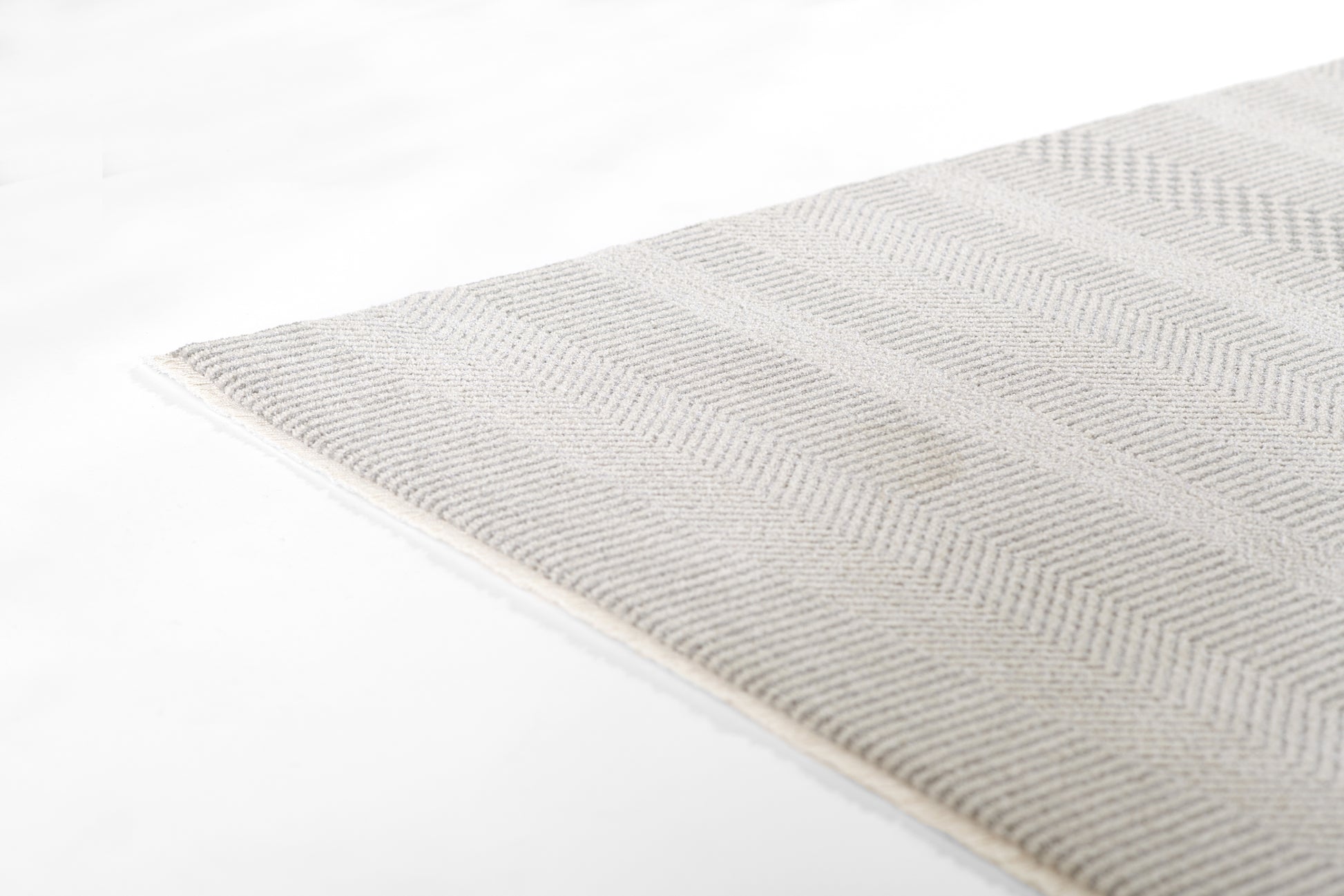 Light gray woven rug with subtle chevron pattern; soft textured fabric, rectangular shape for modern home decor.