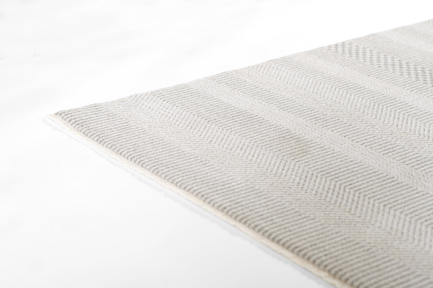 Light gray woven rug with a subtle chevron pattern, rectangular, soft textured floor decor.