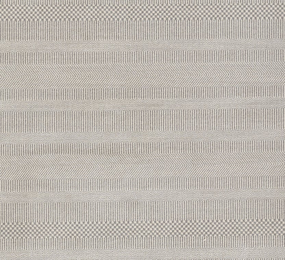 Light gray woven rug with varied stripe textures and subtle chevrons.