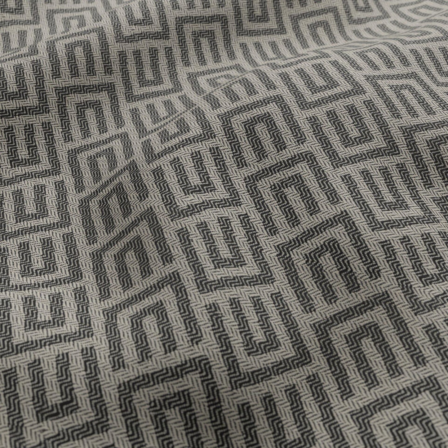 Black and white geometric jacquard outdoor fabric with a Greek key maze pattern.