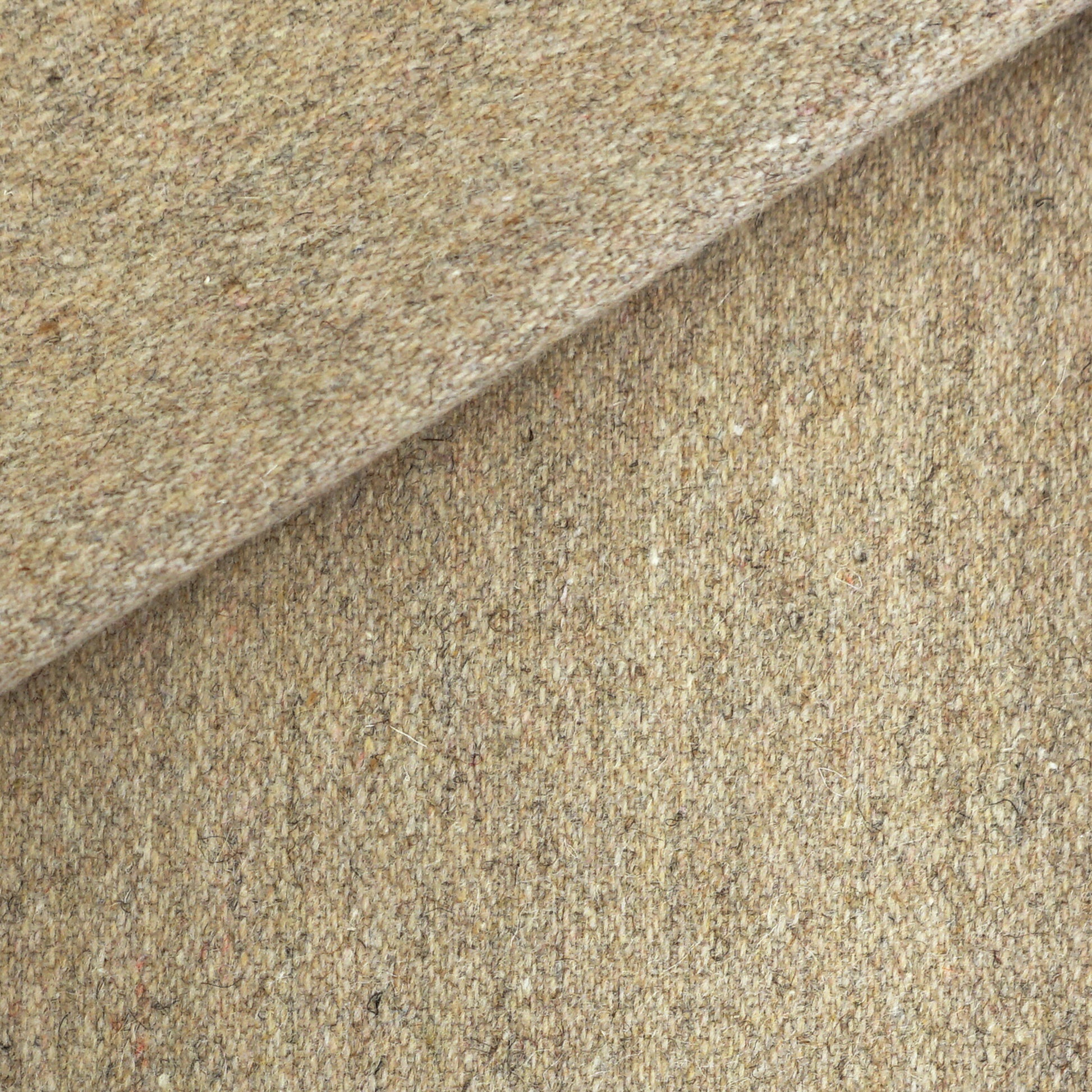 Beige speckled tweed wool fabric, folded to show textured weave; ideal for suits or upholstery.