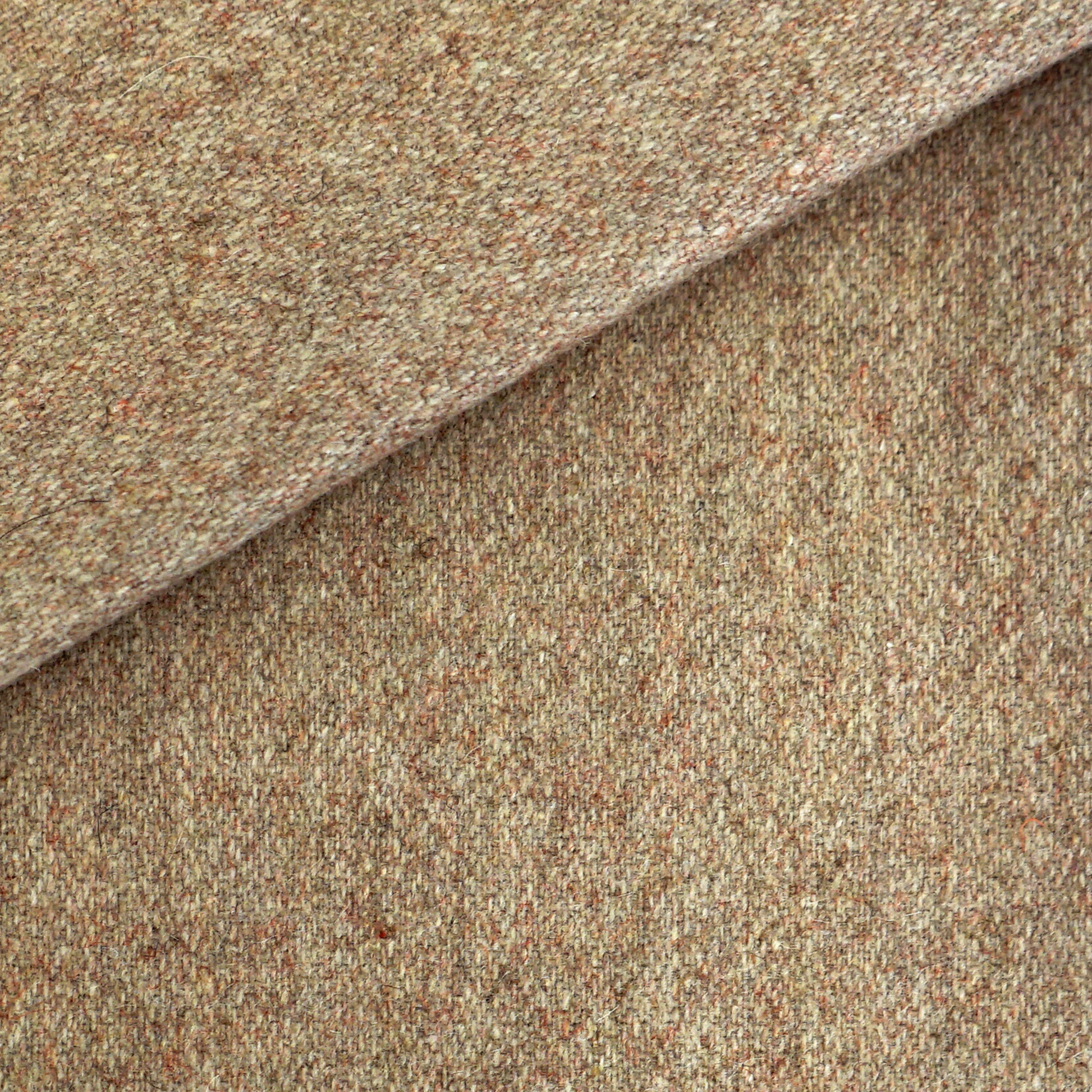 Creme beige tweed wool fabric with beige and tan flecks, folded to show dense textured weave.