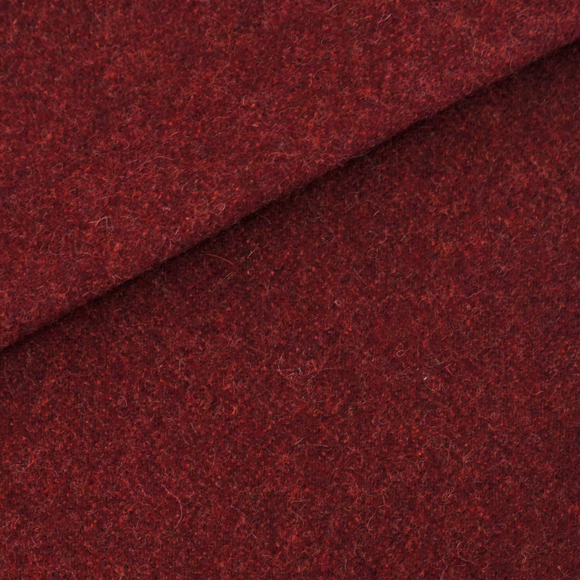 Rich burgundy wool fabric close-up with a diagonal fold; soft flecked texture, ideal for coats.