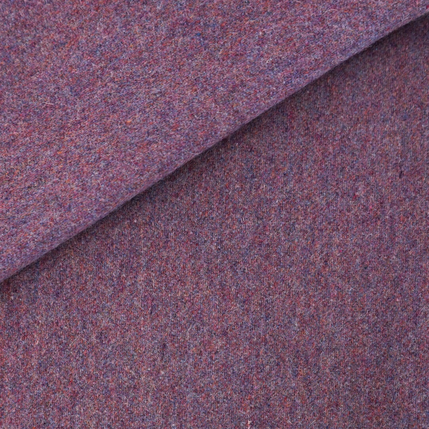 Purple heathered wool fabric, folded at the top corner; cozy tweed textile.