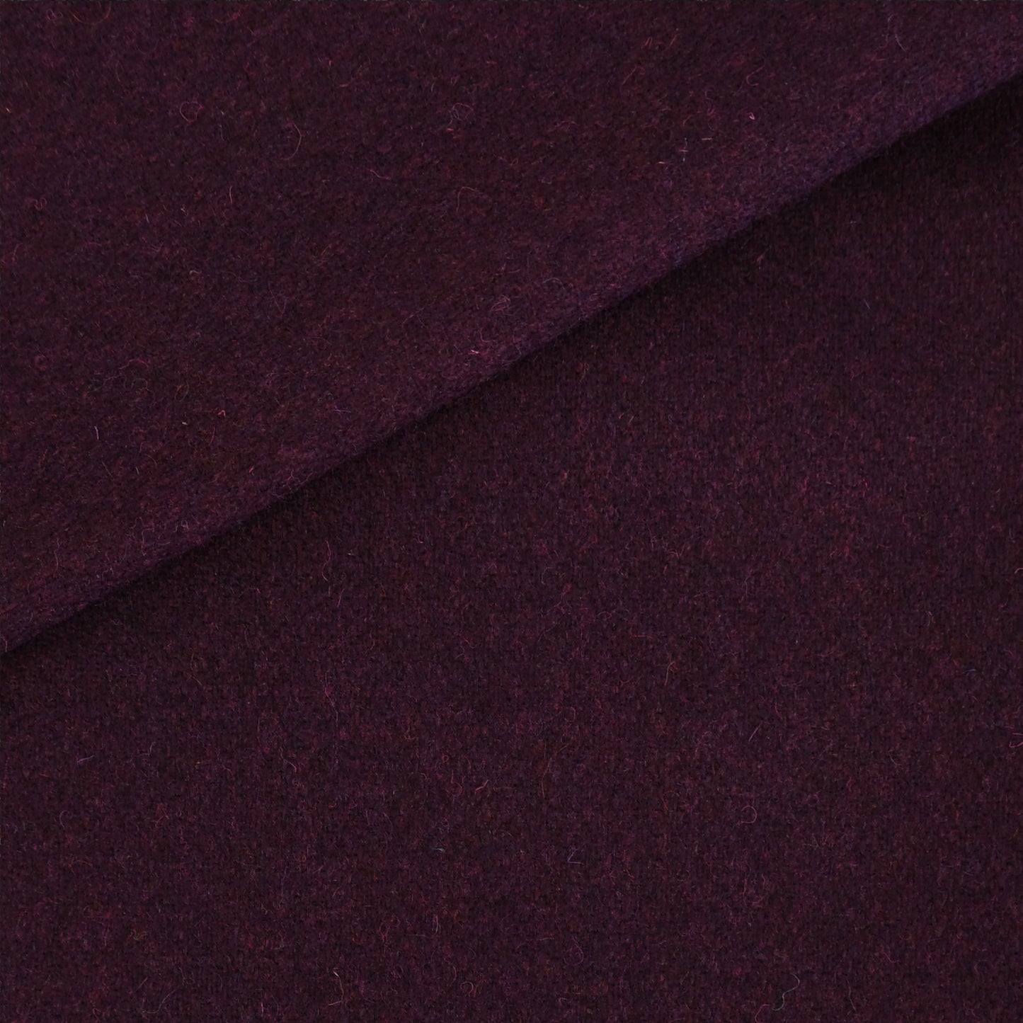 Deep purple wool fabric with a diagonal fold; soft, textured material for coats or crafts.