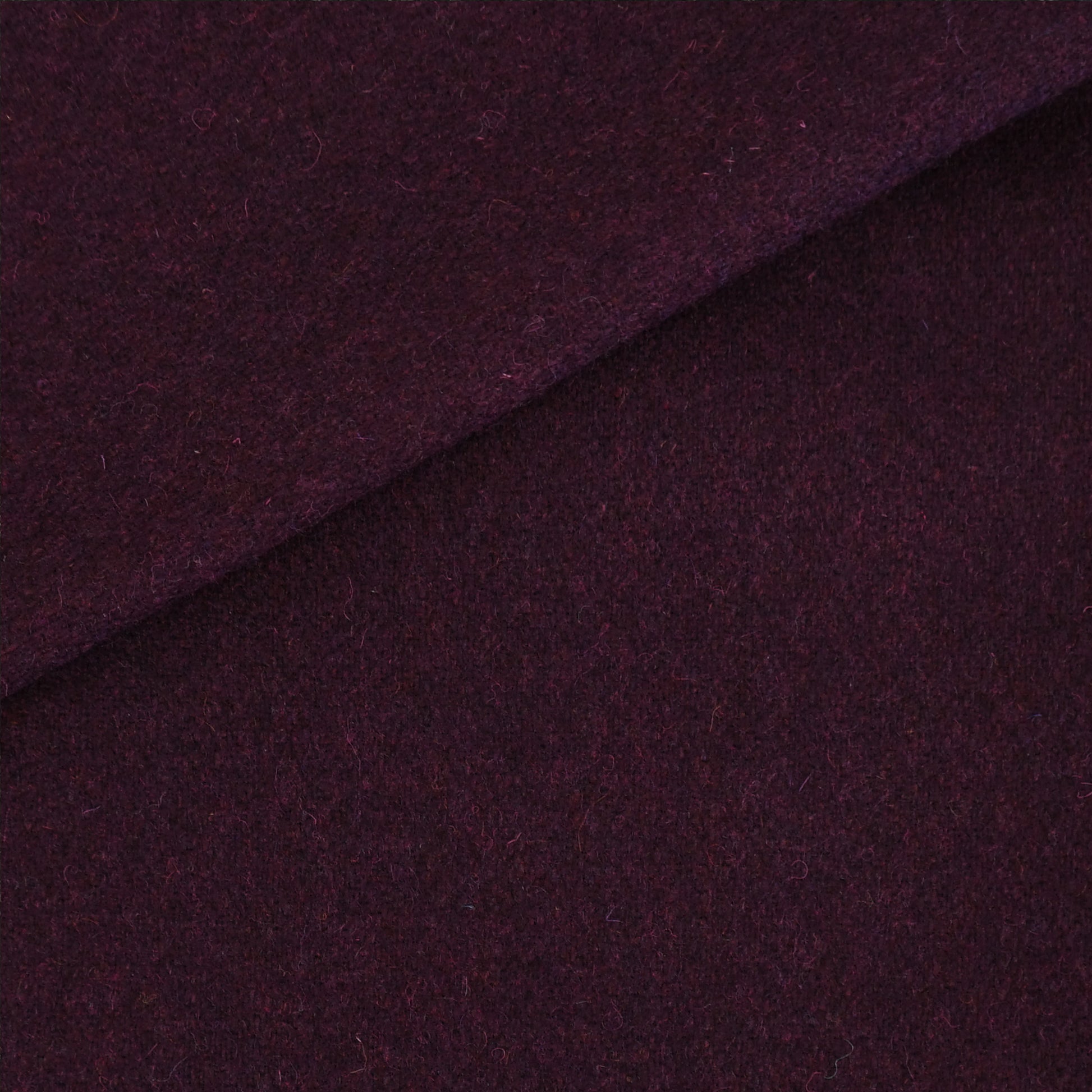 Deep purple wool fabric with a diagonal fold; soft, textured material for coats or crafts.