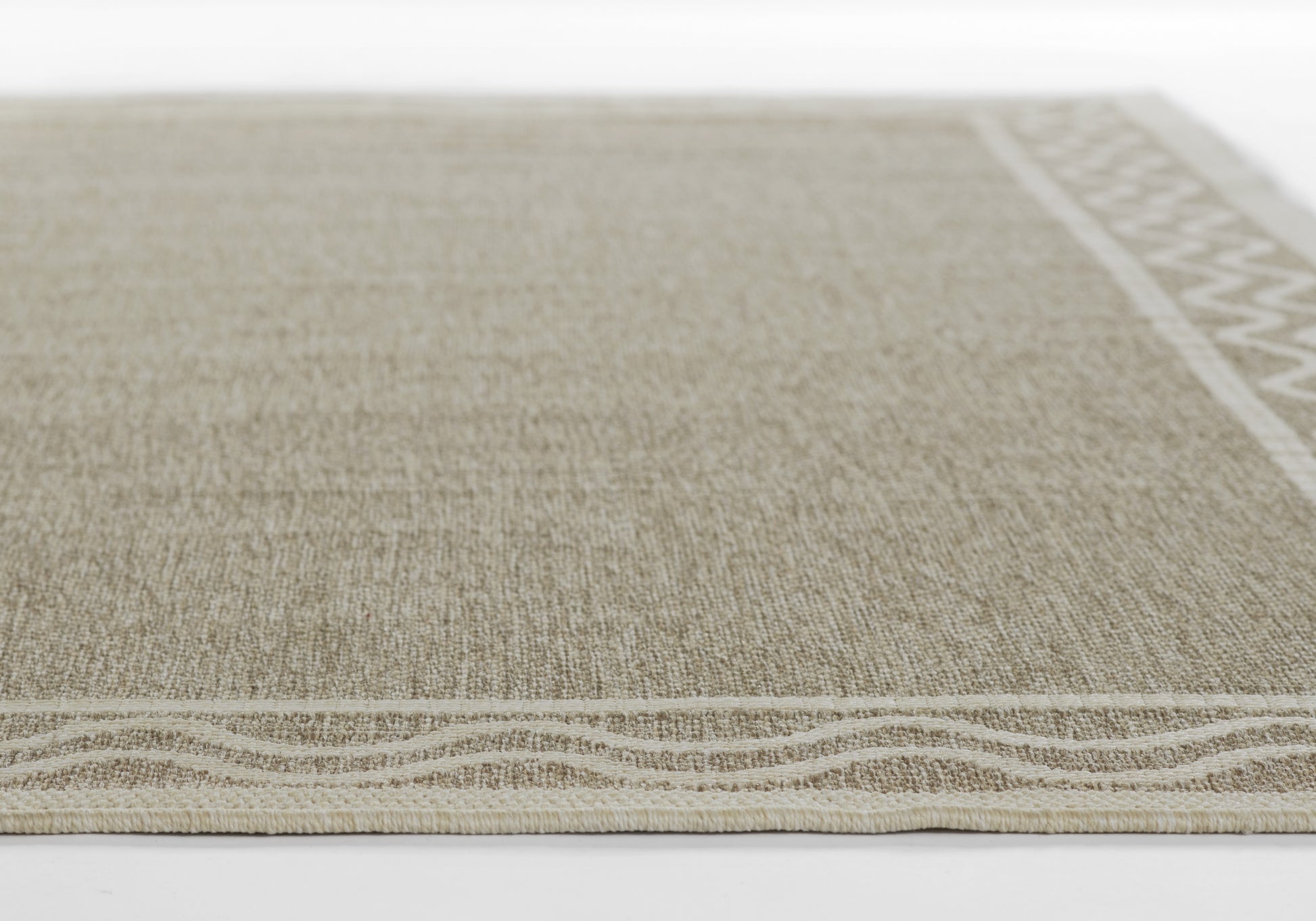 Beige natural-fiber woven rug, rectangular with subtle texture and light wavy border along the edge.