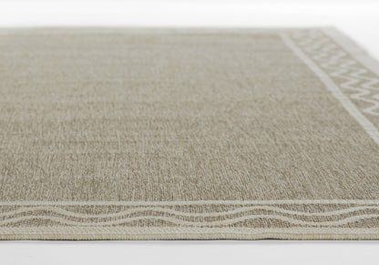 Beige woven rug with natural fiber texture, cream wavy border along bottom and geometric trim on the right edge.