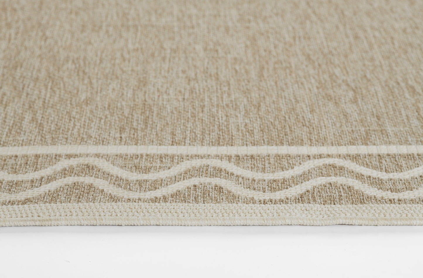 Gray woven rug with a cream wavy border along the bottom edge; natural fiber texture.