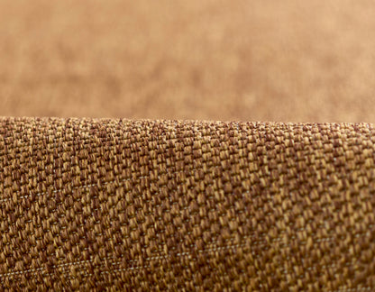 Close-up of brown woven rug fabric with a tight, textured weave in warm tan-brown tones.