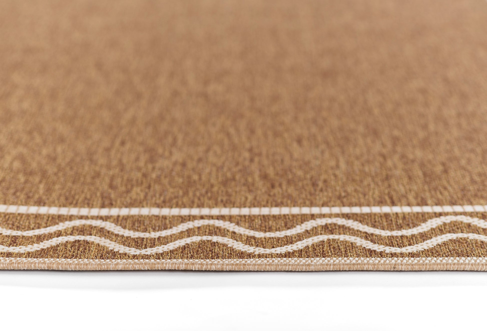 Natural cork rug with white wavy border along the edge.
