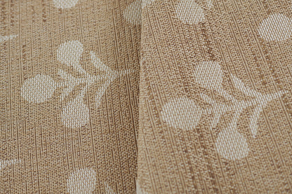 Beige woven rug with white botanical leaf motif and textured vertical stripes.