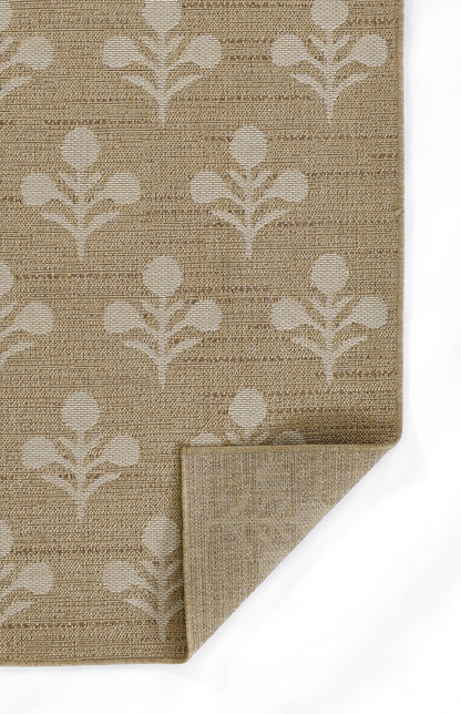 Beige woven rug with pale cream botanical leaf motif; folded corner shows textured natural weave.