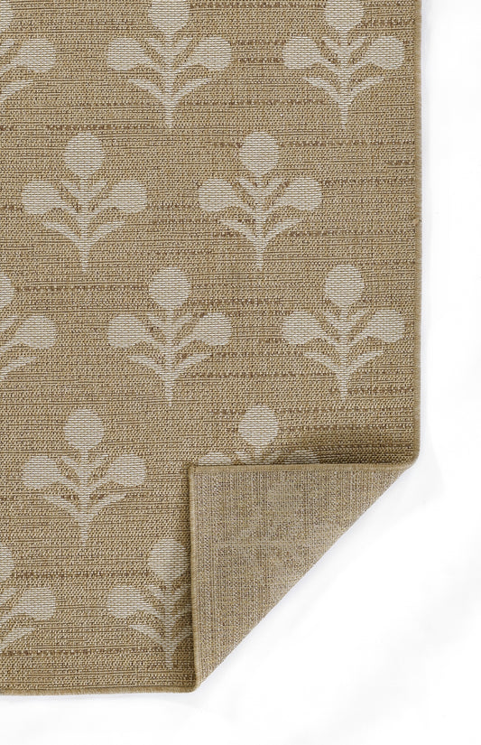 Beige natural-fiber rug with white botanical leaf pattern; woven texture, folded corner.