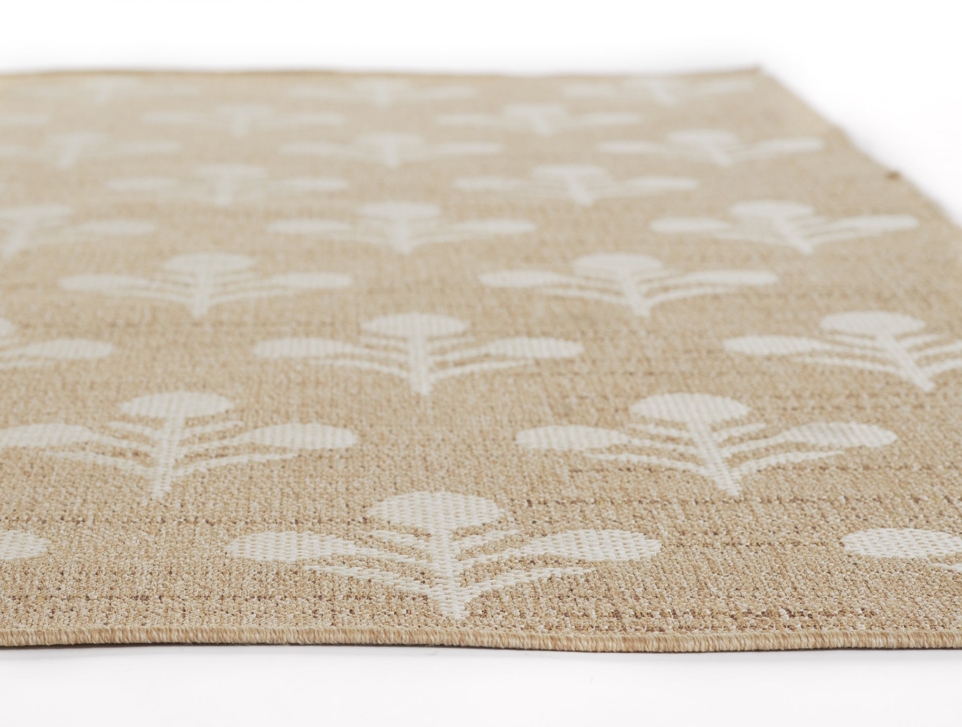 Beige jute rug with white leaf-and-tree motifs in a repeating pattern; natural woven texture.