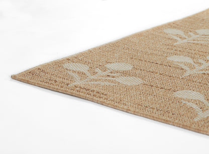 Beige woven rug with white leaf pattern, natural jute texture, close-up corner view.