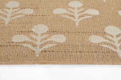 Beige jute rug edge with white leaf motif; natural, textured floor mat for entryway or living spaces.