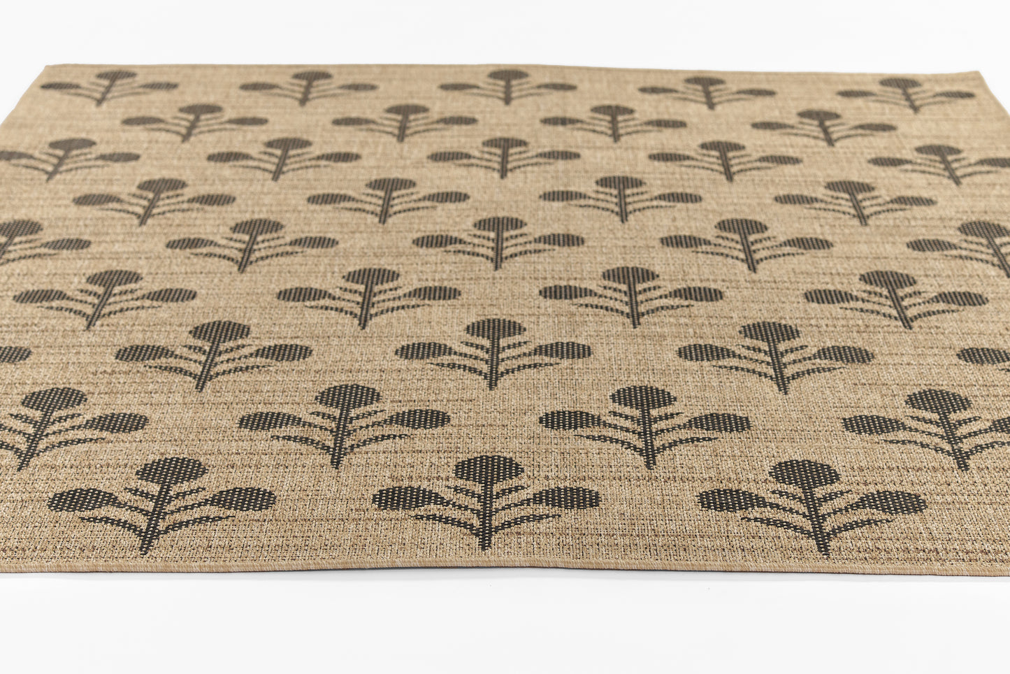 Natural jute rug with repeating black palm-tree style motifs; rustic farmhouse woven texture.