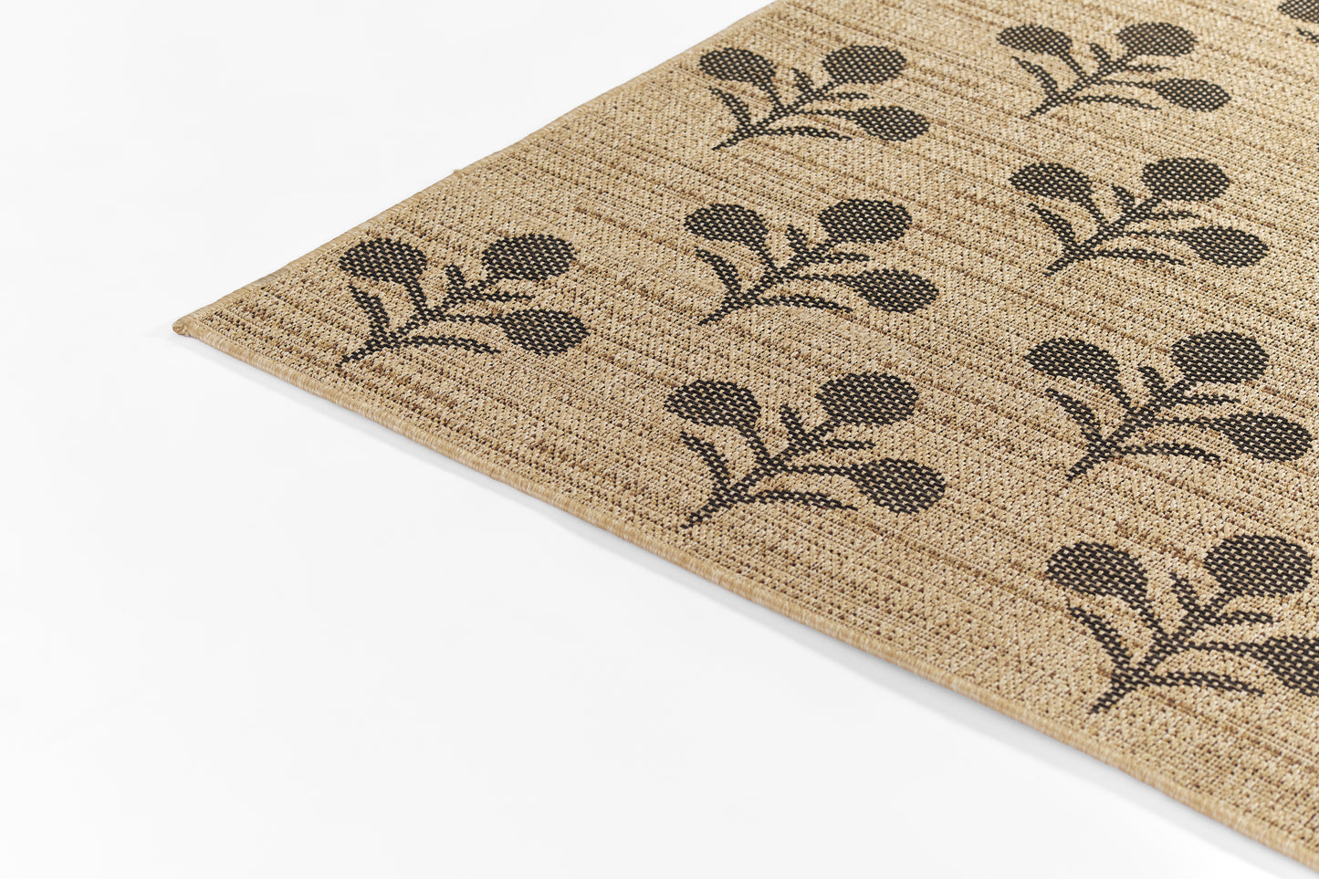 Natural jute rug with repeating black botanical leaf motif on beige background