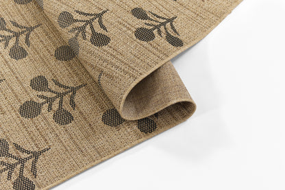 Beige jute rug with black berry-stem botanical print, rolled edge, rustic natural decor.