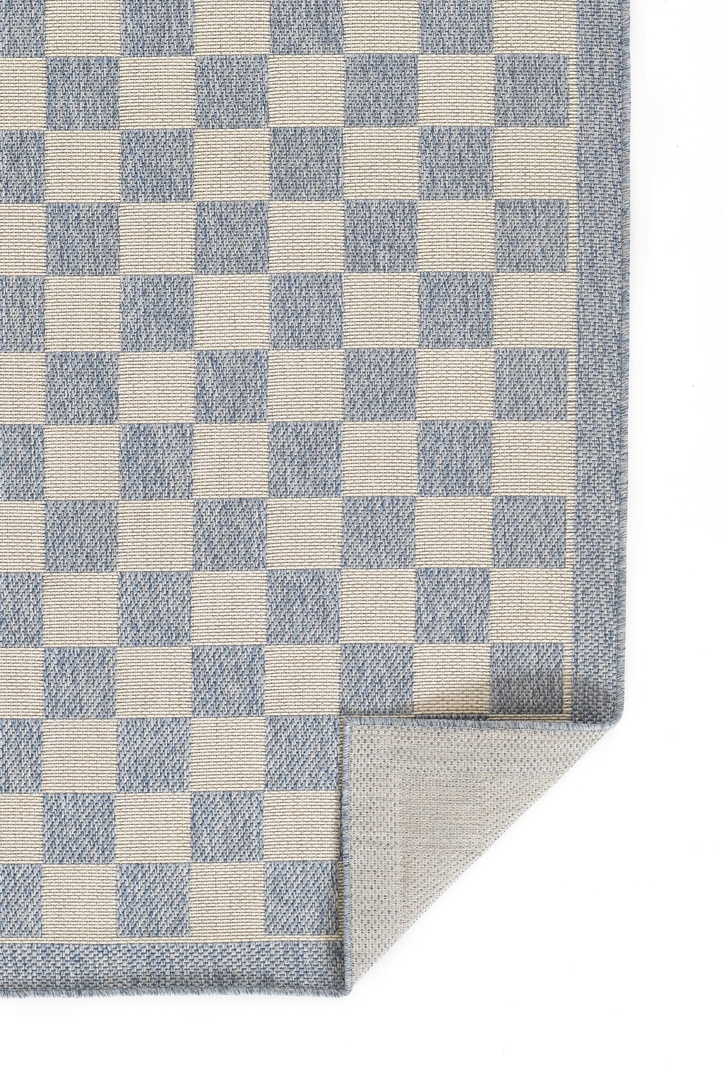 Blue and cream checkerboard woven rug with a denim-blue border; rectangular rug, corner folded.