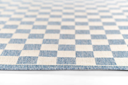 Blue and ivory checkerboard runner rug, woven textile with a visible folded edge, geometric modern rug.