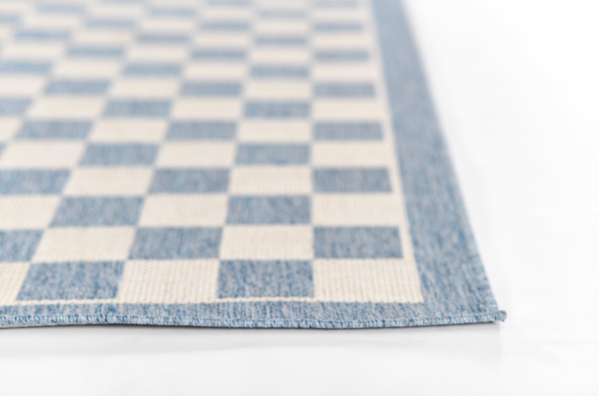 Blue and white checkerboard woven runner rug with textured surface and blue edge trim, 2' x 8'.