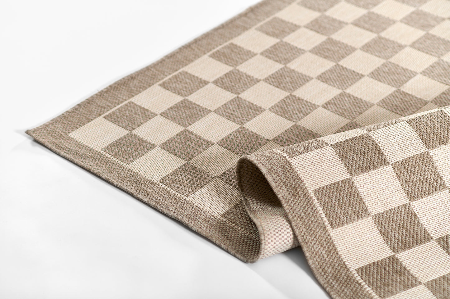 Beige and brown checkered woven rug, rectangular with folded corner.
