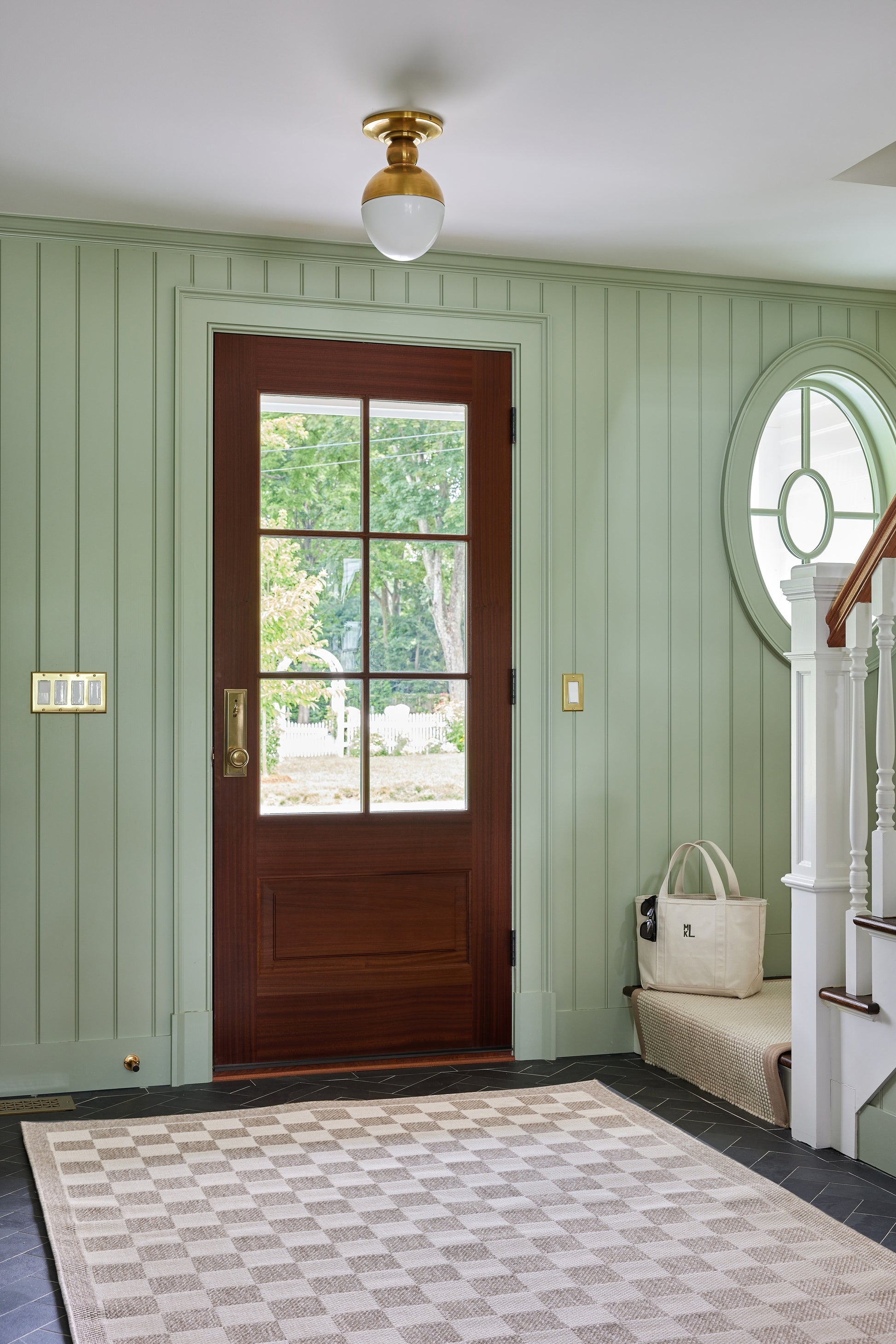 Gray checker rug in a mint green beadboard entryway.