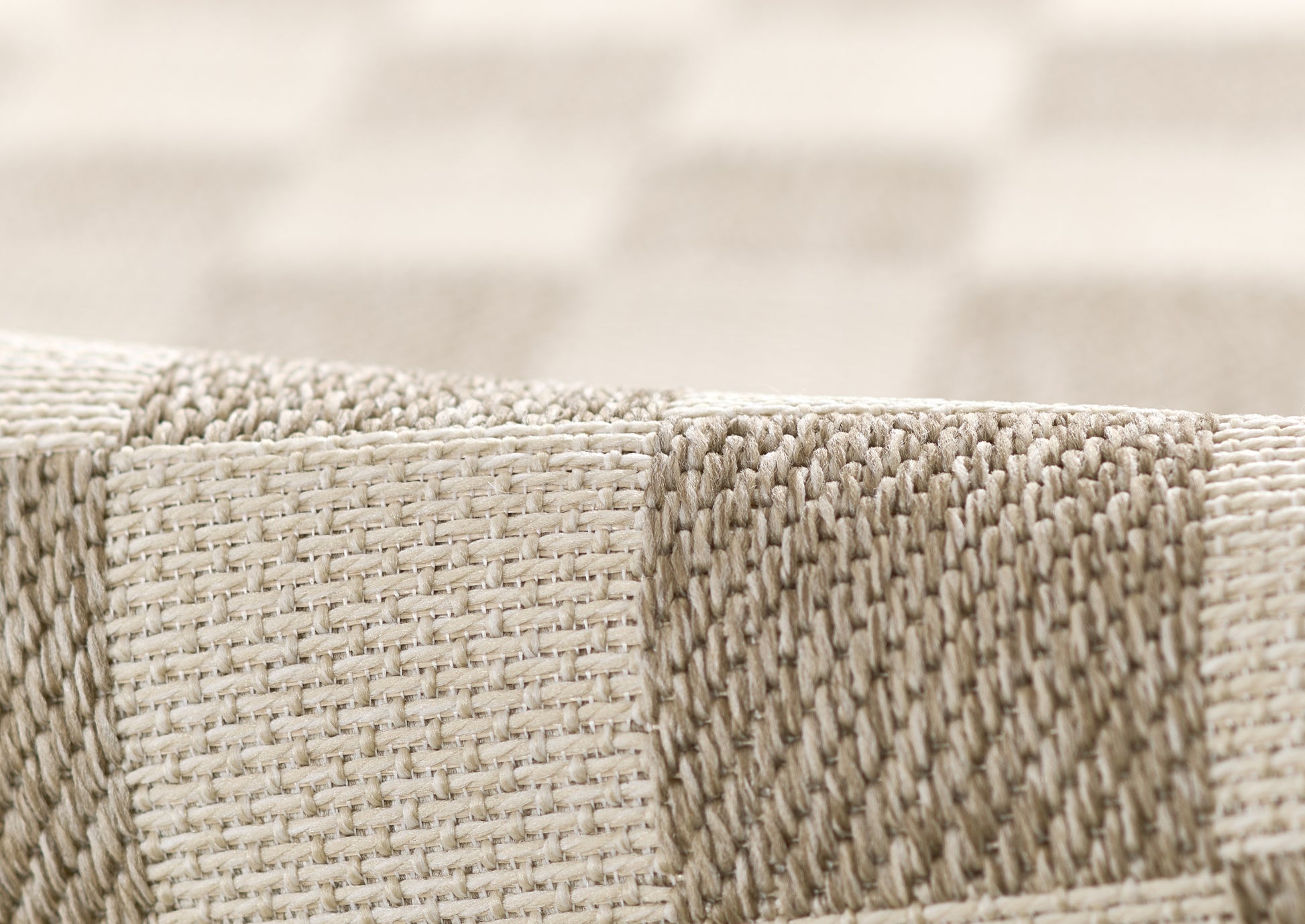 Beige and gray striped woven rug with thick, textured weave and edge seam.