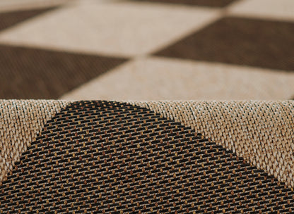 Close-up of a textured woven rug in beige and black with a bold checkered geometric pattern.