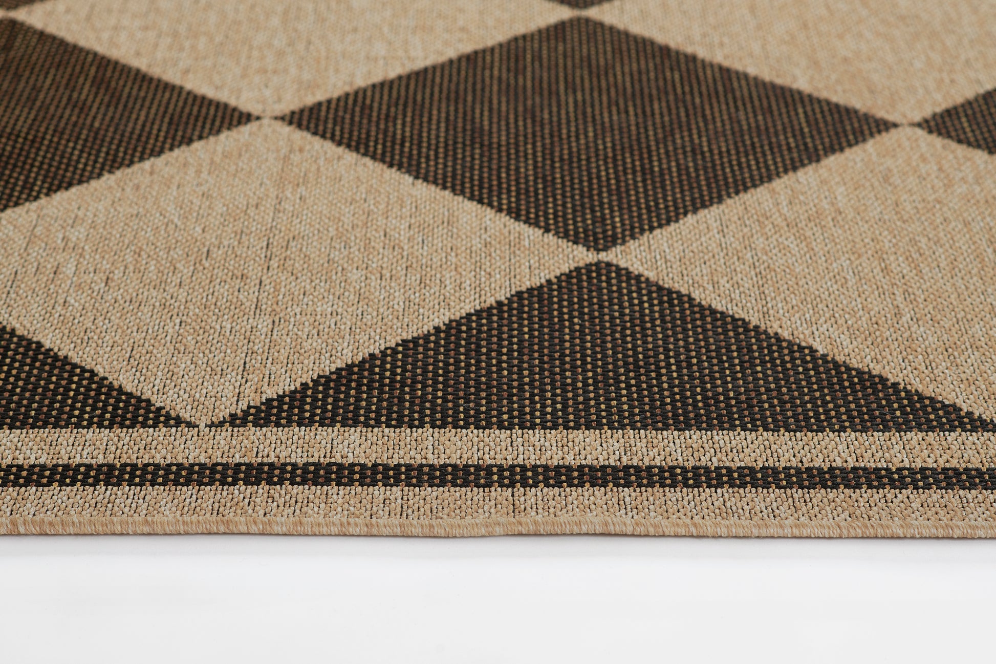 Beige and black woven rug with large argyle diamonds; geometric, natural fiber texture, bordered.