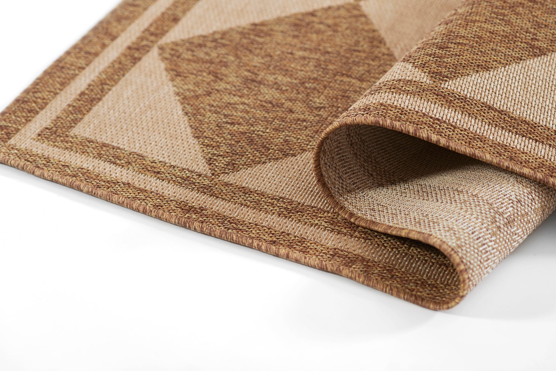 Beige and brown geometric woven rug with natural jute-like texture, folded edge visible.
