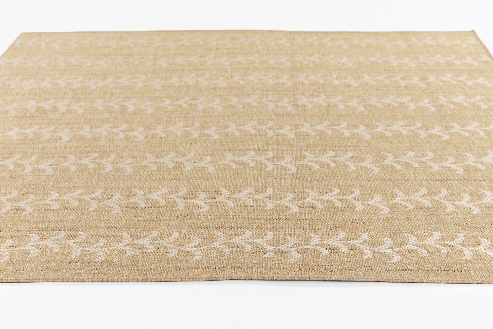 Natural beige jute rug with white leaf trellis pattern; rectangular, woven, casual coastal style.