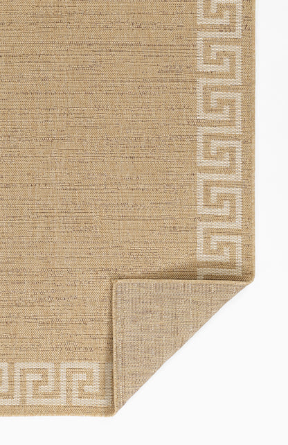Beige natural-fiber flatweave rug with white Greek-key border; rectangular, woven texture with folded corner.