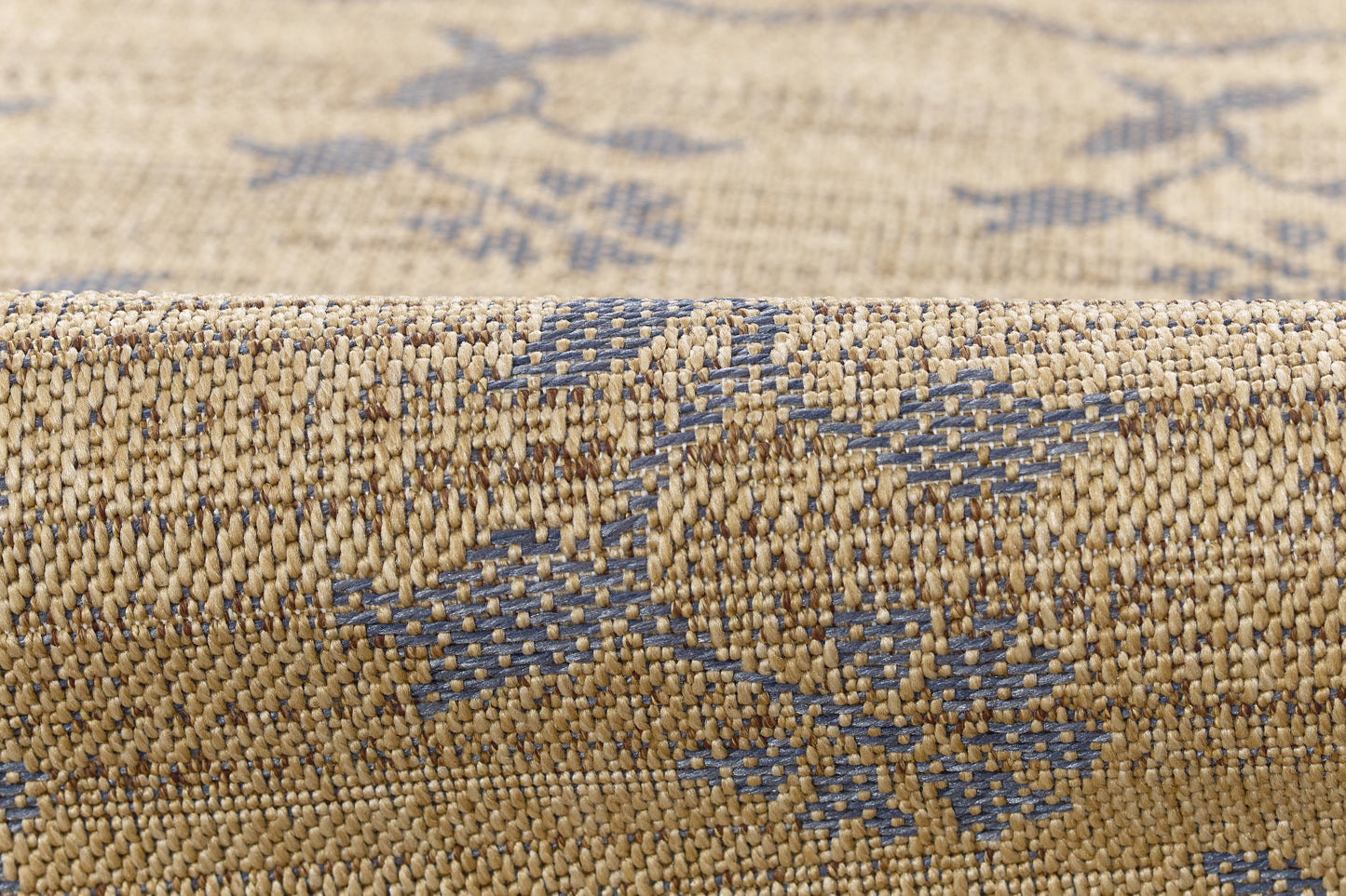Beige woven rug with blue geometric motif; natural jute-like fibers, rolled edge, boho style