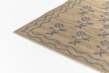 Beige woven rug with blue floral motifs and wavy blue border; natural textured surface.