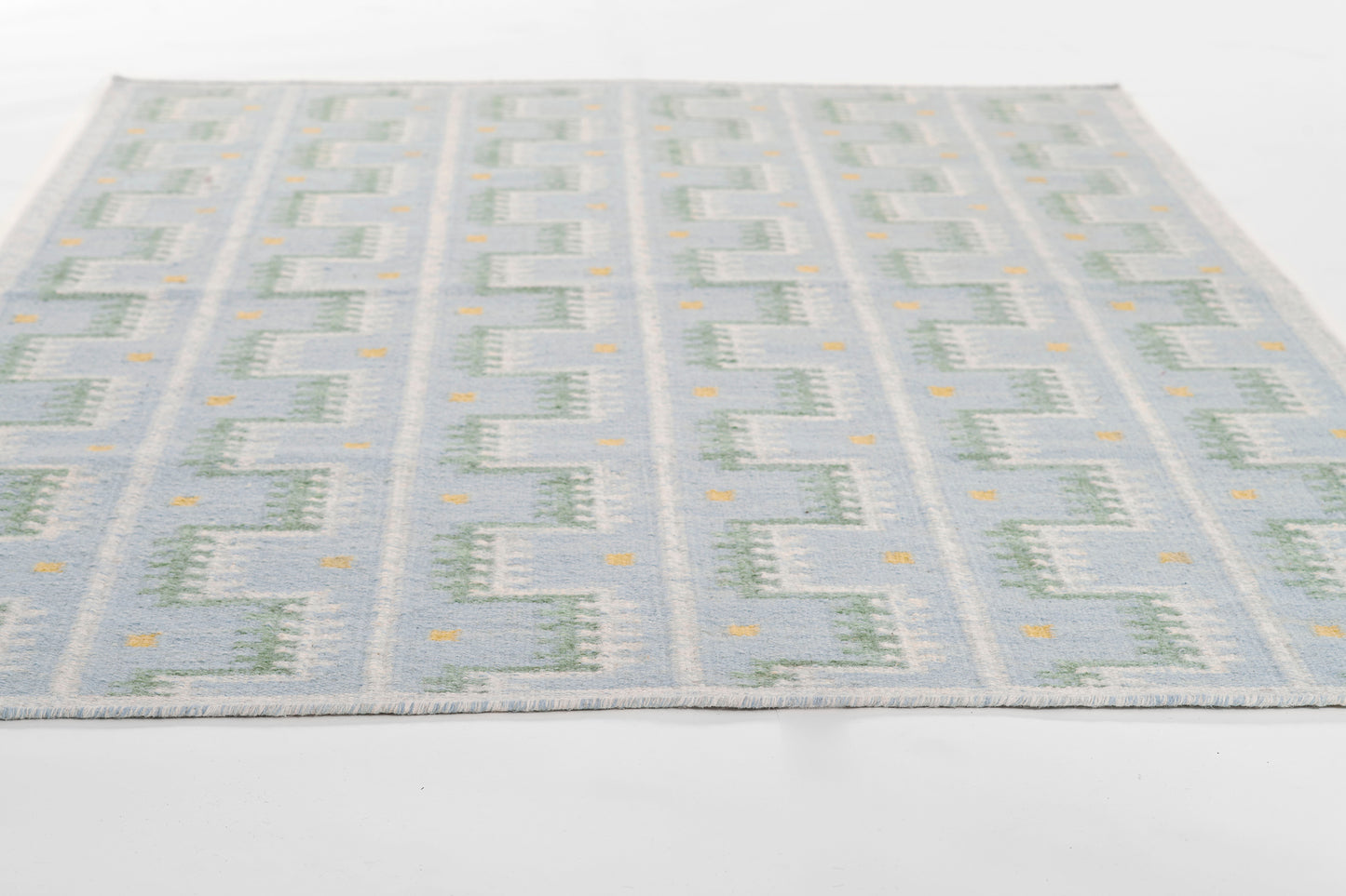 Flatwoven blue and cream geometric rug with tiny orange accents in a Scandinavian-inspired pattern.
