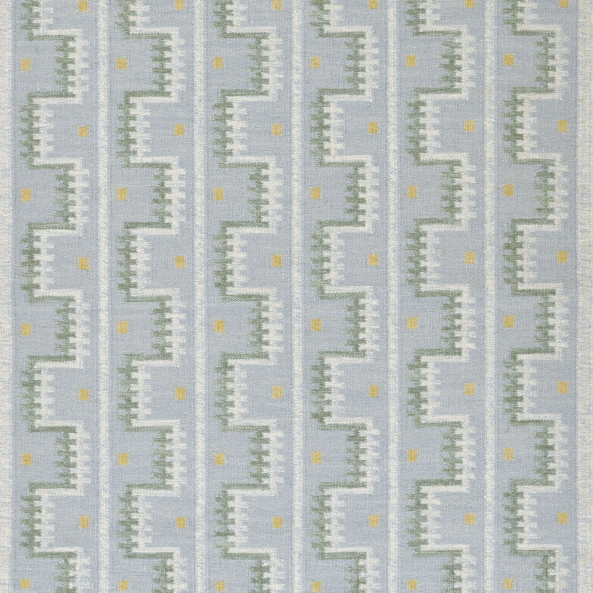 Blue rug featuring a vertical white zigzag stair-step motif with green edges and tiny yellow dots.