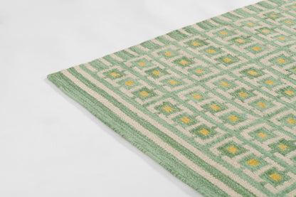Scandinavian green geometric rug with white diamond pattern and yellow accents; woven with green border.