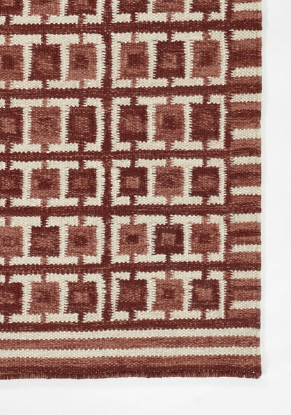 Scandinavian red-brown and beige geometric rug with square motifs and striped border.