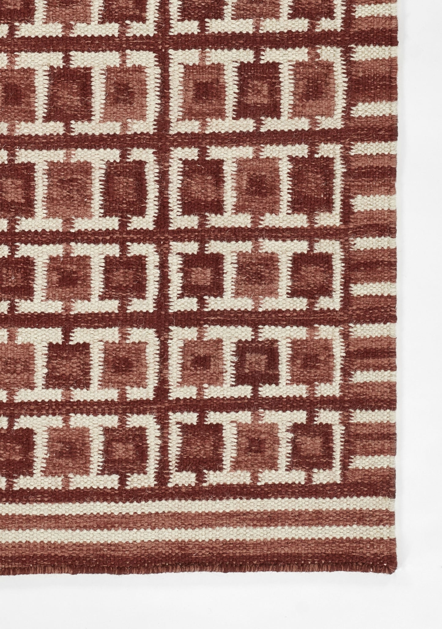 Red and cream woven rug with repeating interlocking square borders; geometric Scandinavian style, rectangular floor rug.