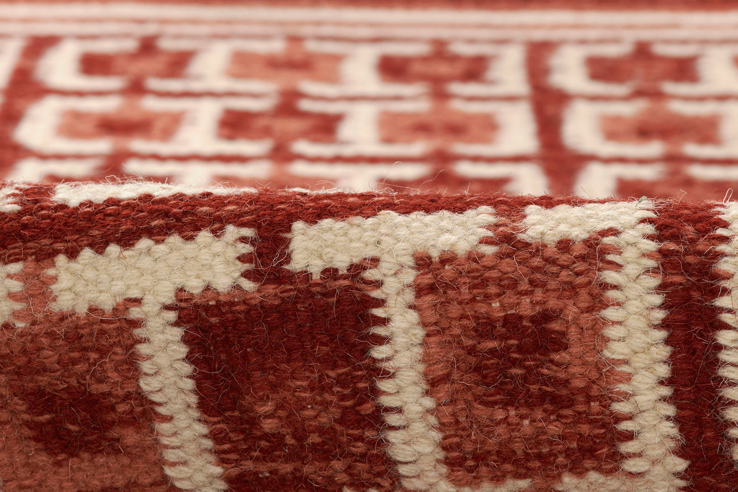 Scandinavian-style woven rug in red and ivory with bold geometric blocks and soft plush pile.