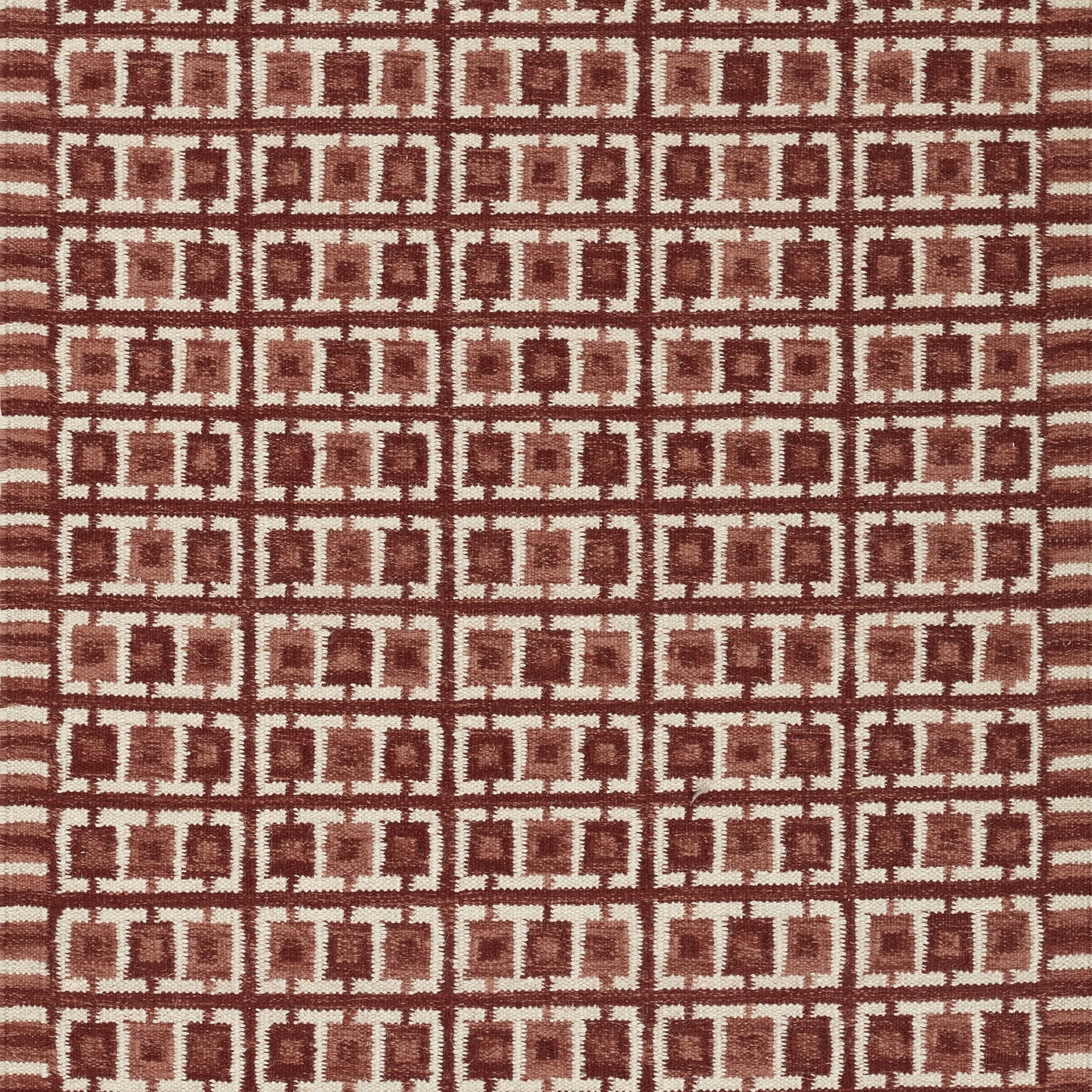 Nordic-inspired red fabric with beige interlocking square lattice; geometric textile.