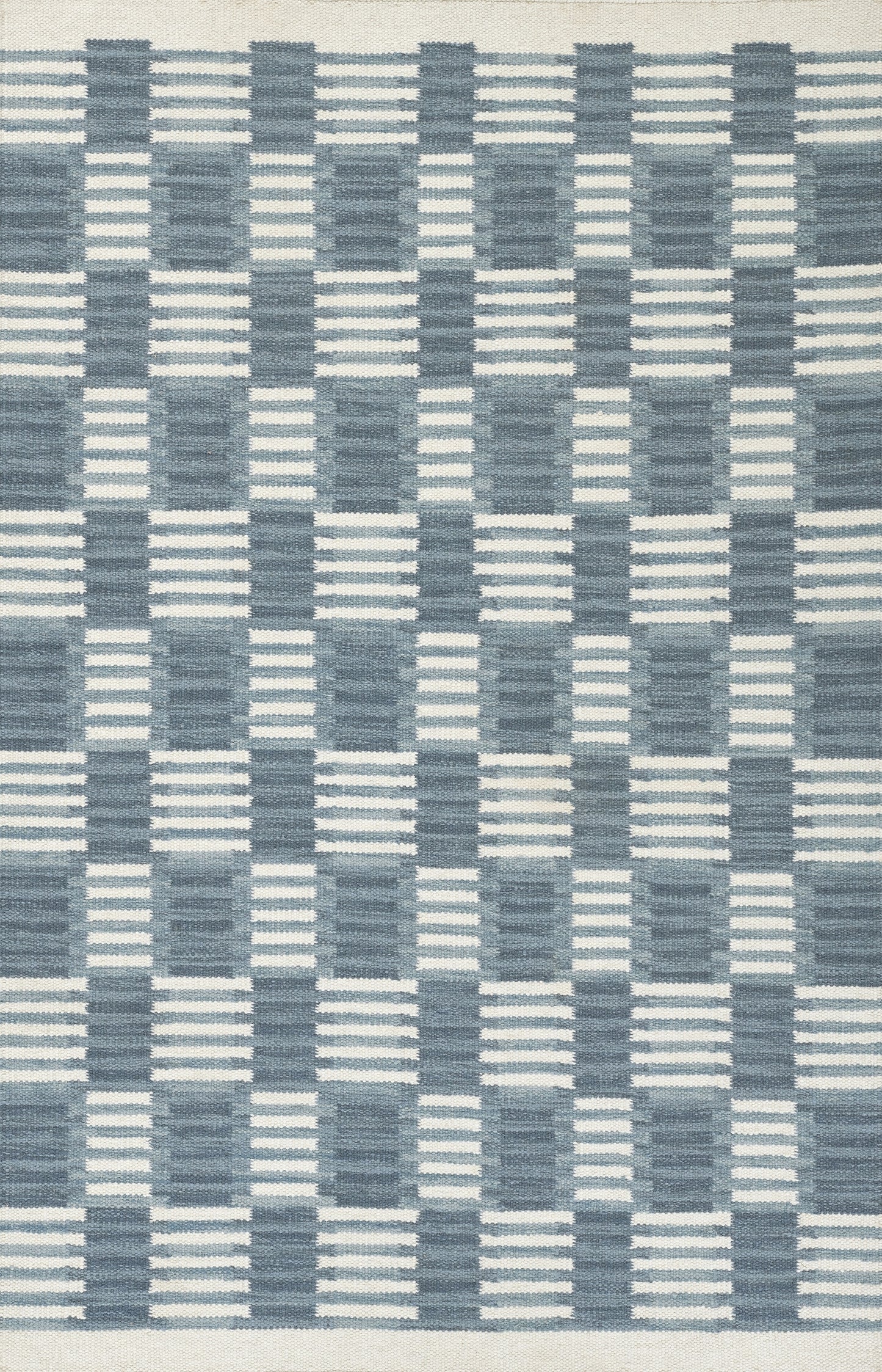 Scandinavian-inspired blue woven rug with navy and light-blue checker/grid pattern, geometric floor decor.