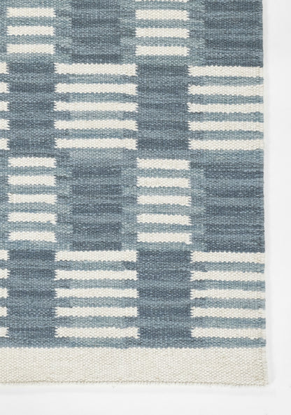 Scandinavian-inspired blue and cream geometric woven rug with rectangular blocks and striped accents.