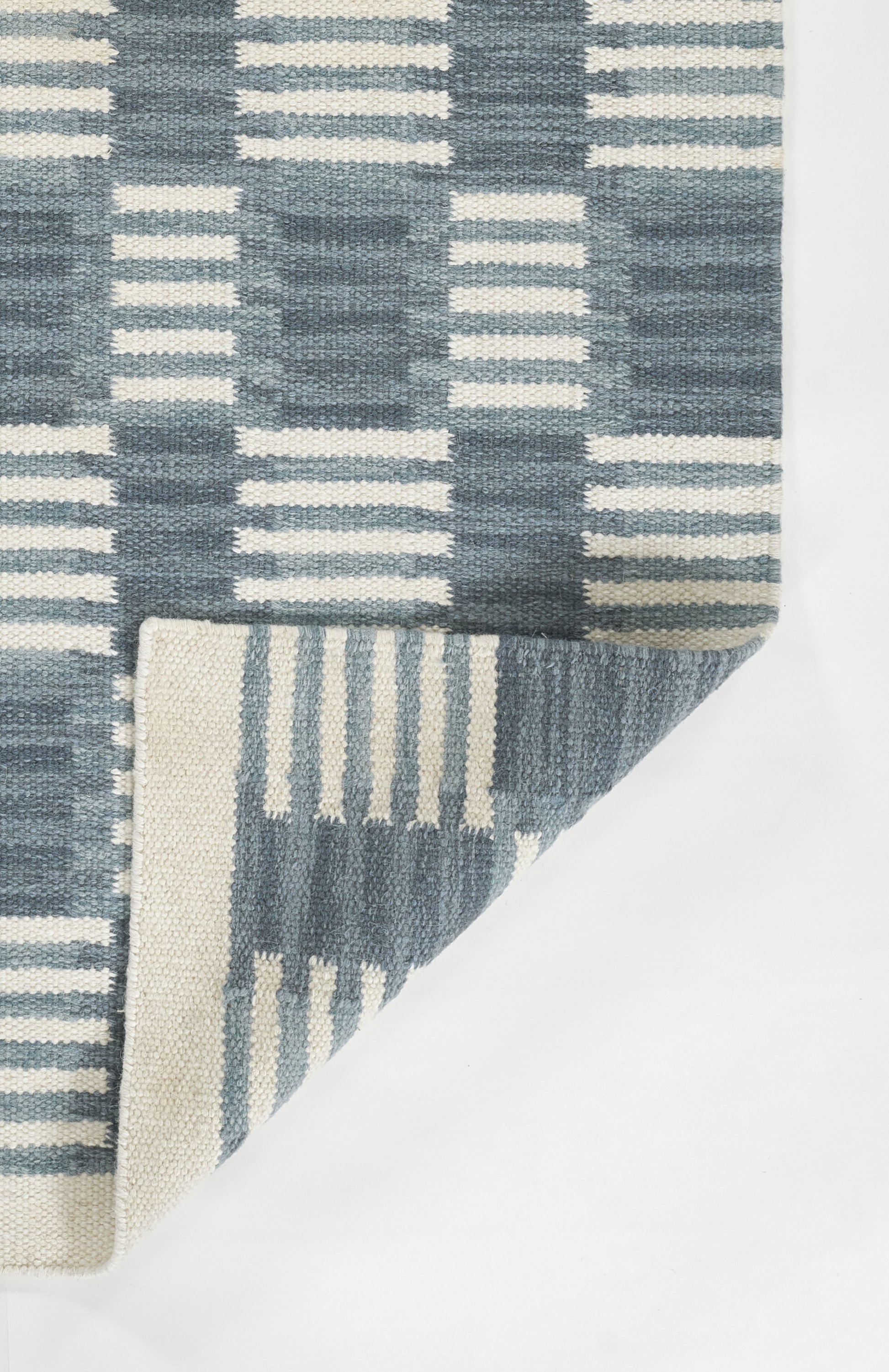 Blue and ivory woven rug with a geometric grid pattern; Scandinavian style floor decor.