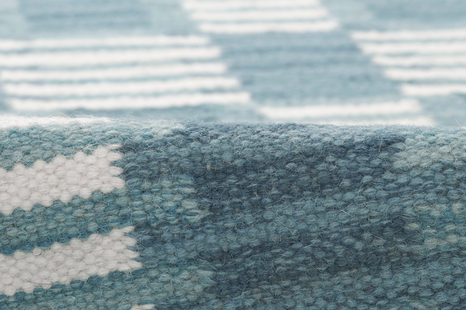 Blue and white geometric patterned rug with soft, textured pile.