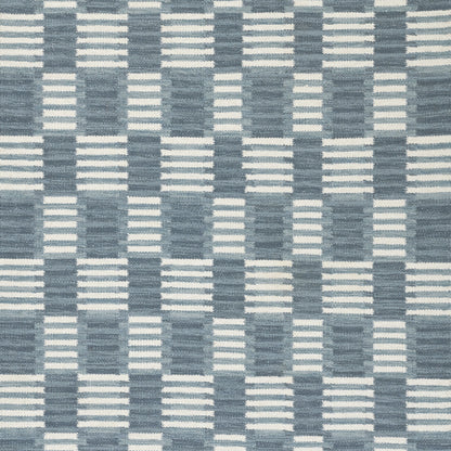 Blue and white woven checkerboard rug with striped blocks; Scandinavian-inspired home decor.