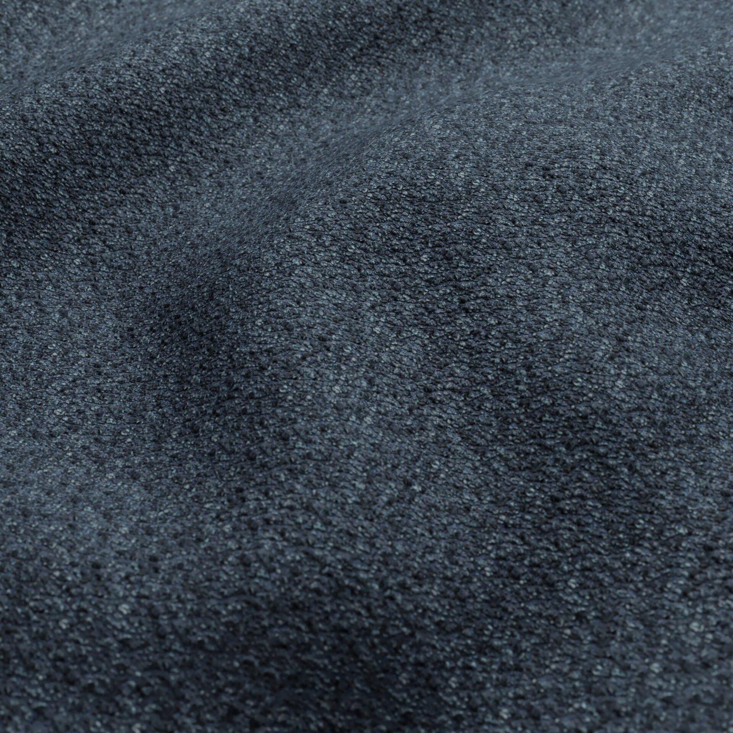 Dark blue and teal boucle fabric close-up with a textured surface.